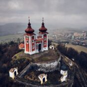 Aerial view of historical church atop on hill. Late baroque calvary in Banska Stiavnica in Slovakia | SUPERPOBYT World